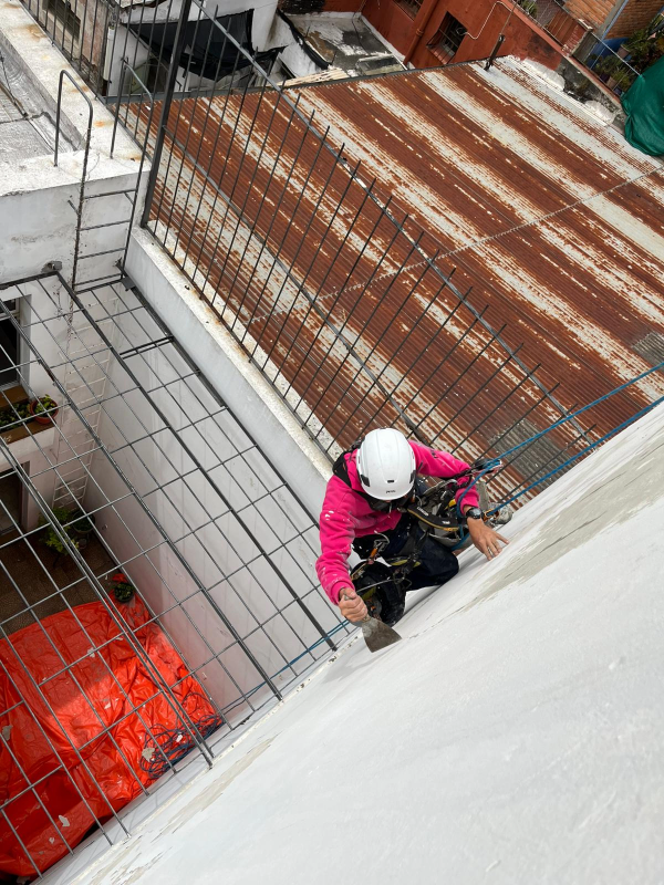 Restauración de fachada en altura con técnicos trabajando con acceso por cuerdas en edificio en Uruguay